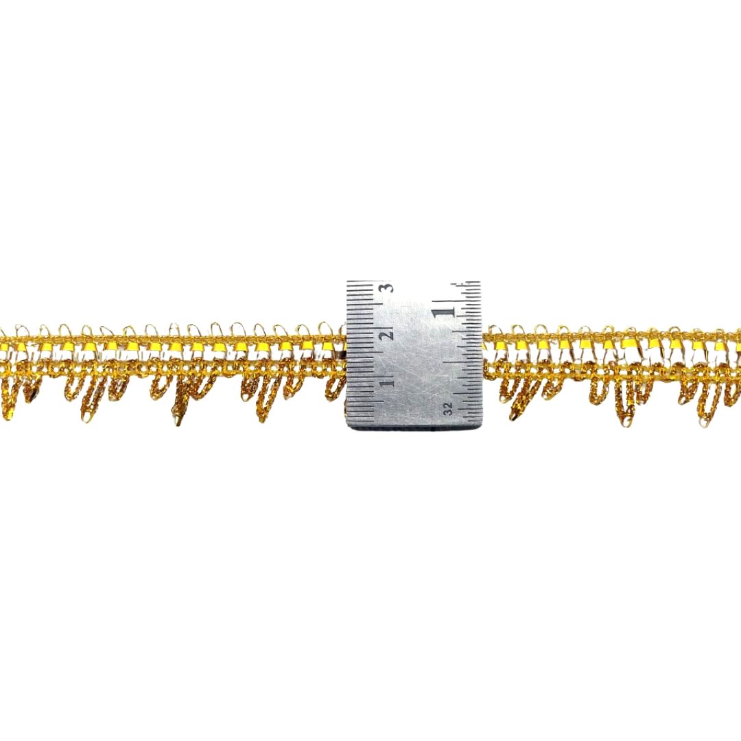 Gold lace trim with a ruler for measurement on a white background